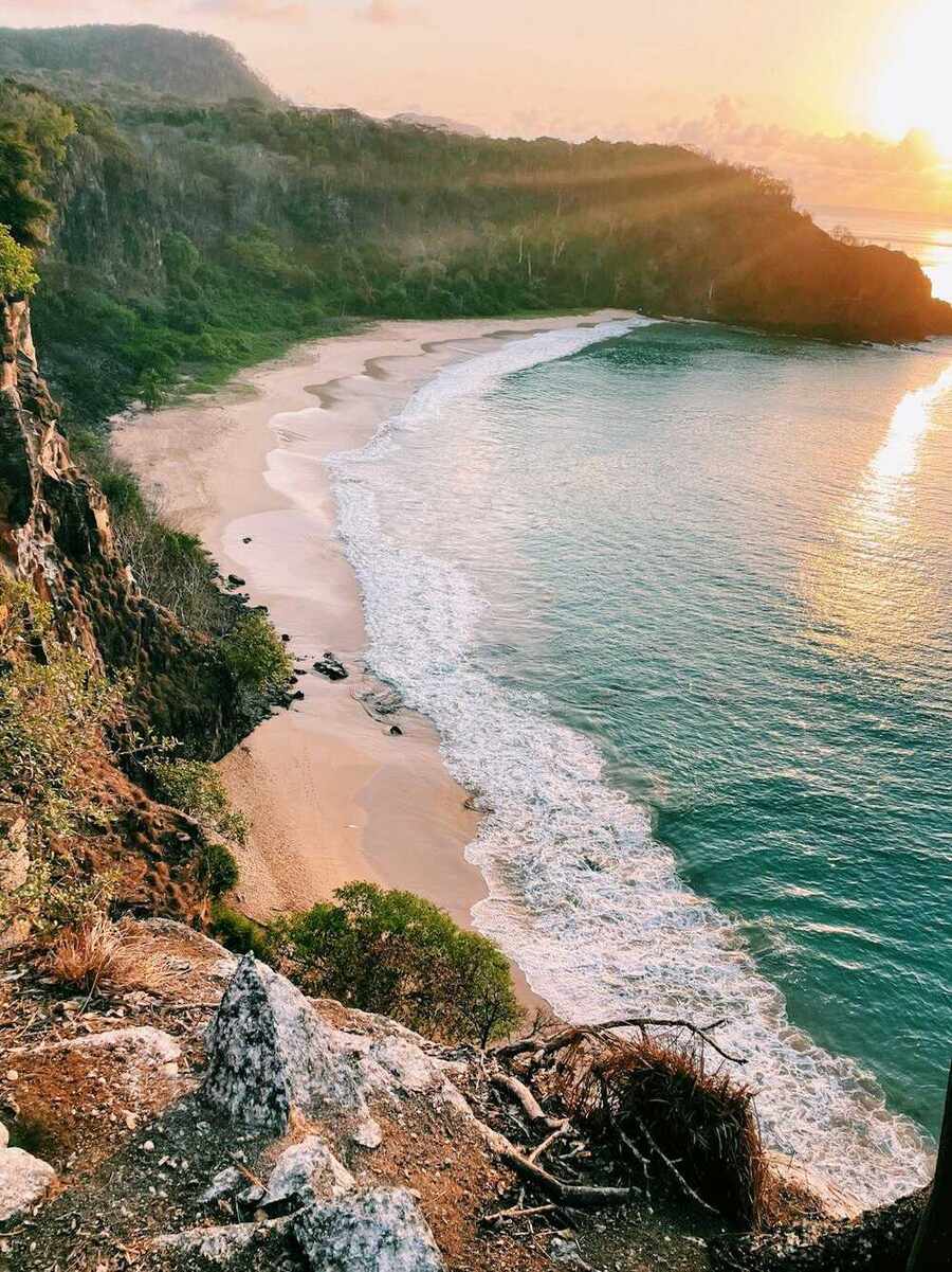 Vista aérea de uma praia de águas claras ao amanhecer